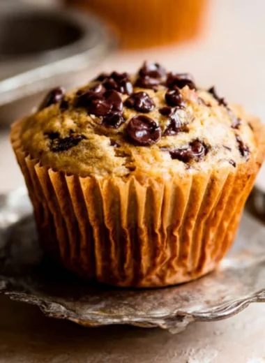 Freshly baked banana chocolate chip muffins on a cooling rack.