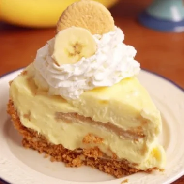 Slice of banana pudding cheesecake garnished with banana slices and whipped cream