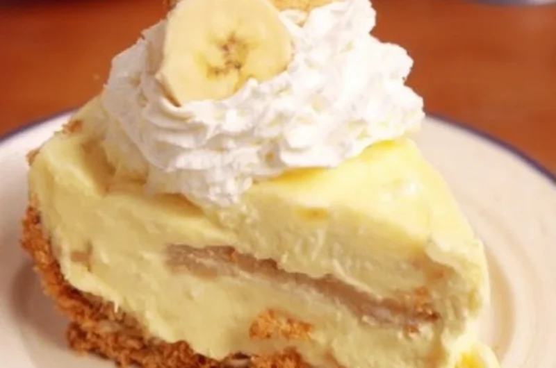 Slice of banana pudding cheesecake garnished with banana slices and whipped cream