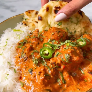 Delicious butter chicken served with rice and naan