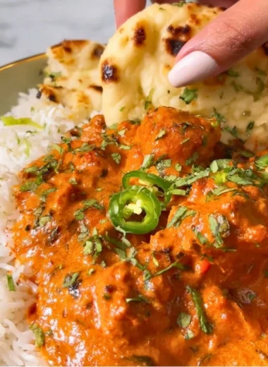 Delicious butter chicken served with rice and naan