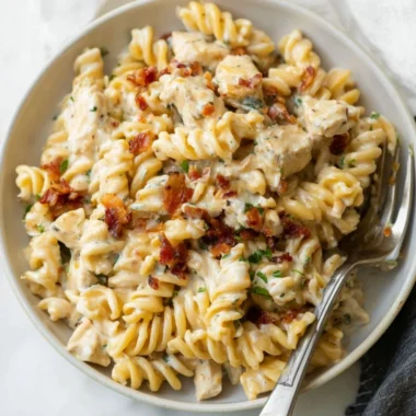 Creamy Chicken Bacon Ranch Pasta topped with fresh herbs and cheese