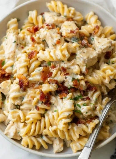 Creamy Chicken Bacon Ranch Pasta topped with fresh herbs and cheese