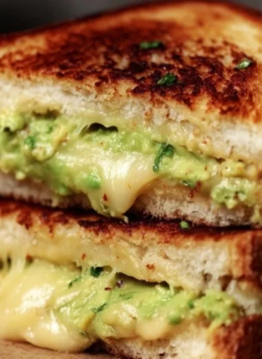 Creamy avocado grilled cheese sandwich with melted cheese and fresh avocado slices.
