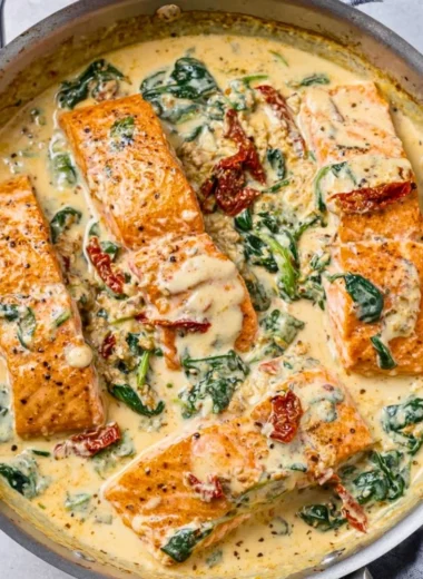 Plate of creamy Tuscan garlic salmon garnished with herbs and served with vegetables.
