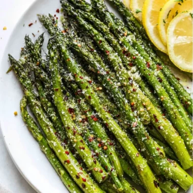 Delicious oven roasted asparagus with Parmesan cheese on a serving plate