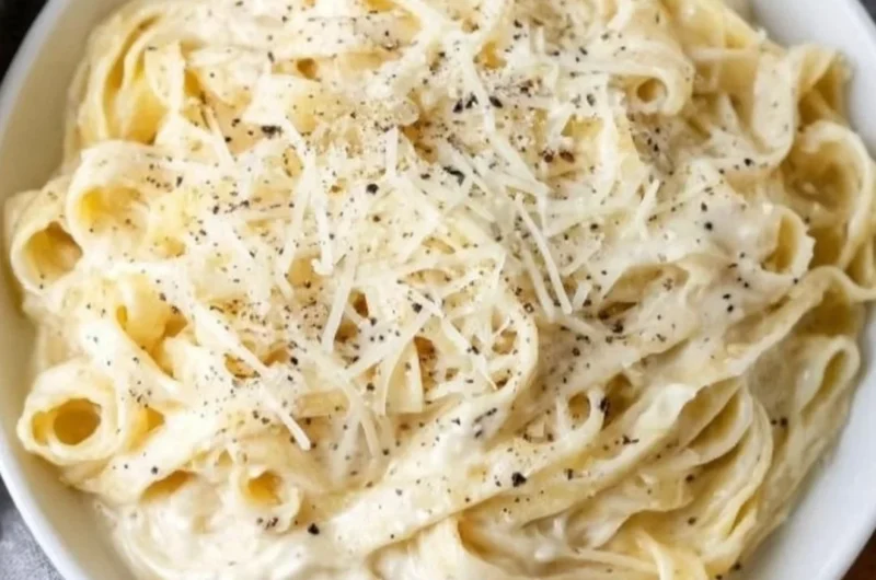 Delicious bowl of Fettucine Alfredo with creamy sauce and parsley garnish