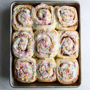 Delicious Funfetti cinnamon rolls topped with colorful sprinkles and icing