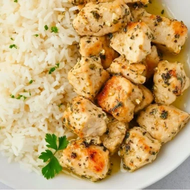 Plate of crispy Garlic Chicken Bites garnished with herbs
