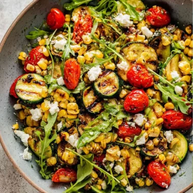 Colorful grilled zucchini salad with fresh vegetables and dressing
