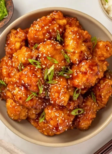 Plate of Honey Sesame Chicken garnished with sesame seeds and green onions