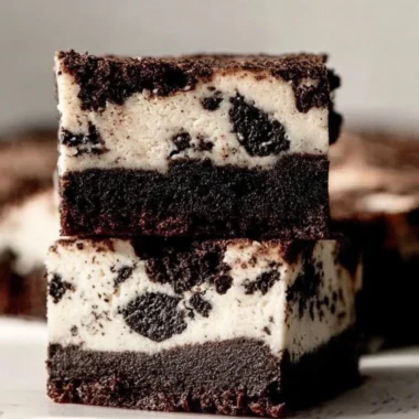 Oreo Cheesecake Brownies with creamy layers and Oreo cookie crumbles on top.