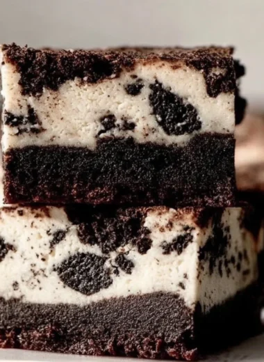 Oreo Cheesecake Brownies with creamy layers and Oreo cookie crumbles on top.