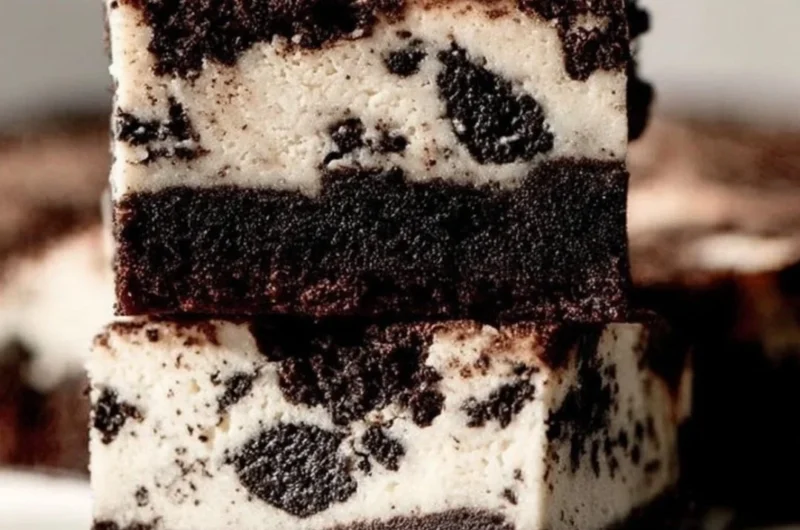 Oreo Cheesecake Brownies with creamy layers and Oreo cookie crumbles on top.