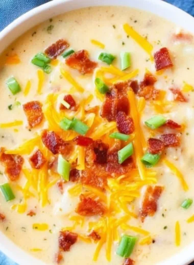 Bowl of creamy slow cooker potato soup garnished with herbs.