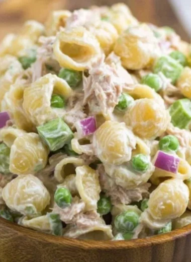 A bowl of fresh Tuna Pasta Salad topped with vegetables and herbs