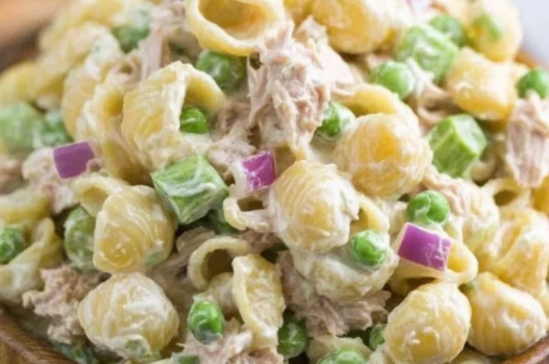 A bowl of fresh Tuna Pasta Salad topped with vegetables and herbs