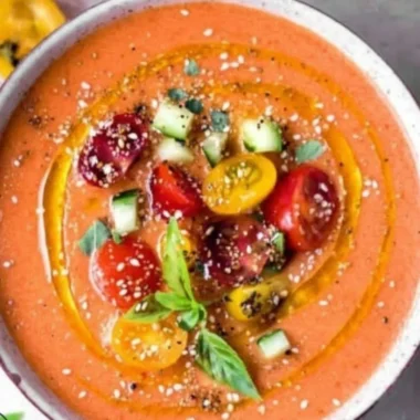 Bowl of authentic Tomato Gazpacho served with fresh vegetables and herbs