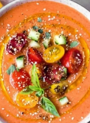 Bowl of authentic Tomato Gazpacho served with fresh vegetables and herbs