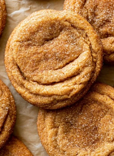 Chewy Pumpkin Snickerdoodle Cookies on a white plate with cinnamon sprinkles