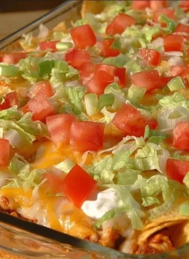 Delicious taco casserole topped with cheese and fresh ingredients.