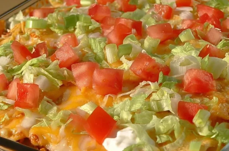 Delicious taco casserole topped with cheese and fresh ingredients.