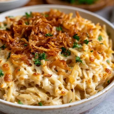 Baked French Onion Orzo topped with melted cheese in a casserole dish