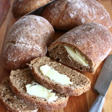 Freshly baked Outback Honey Wheat Bushman Bread loaf on a wooden board.