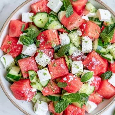 A vibrant watermelon cucumber feta salad served in a bowl with fresh ingredients.