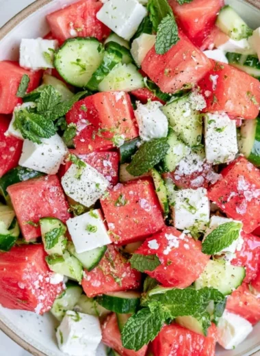 A vibrant watermelon cucumber feta salad served in a bowl with fresh ingredients.