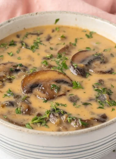 Bowl of Vegan Cream of Mushroom Soup garnished with fresh herbs