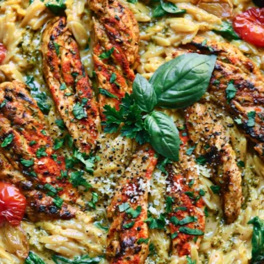 One-pan creamy chicken orzo dish garnished with herbs in a skillet.