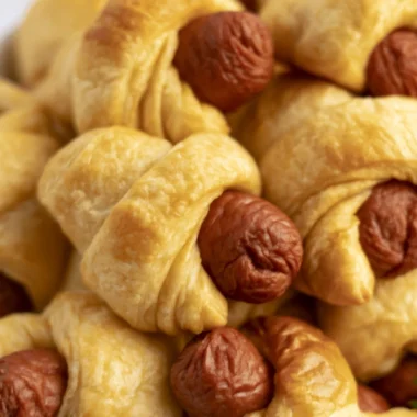 Delicious air fryer pigs in a blanket served with dipping sauce on a plate
