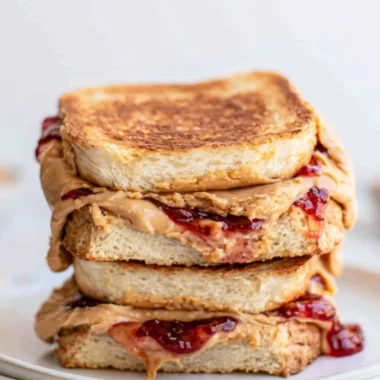 Crispy Air Fryer PB&J sandwich served on a plate with a side of berries.