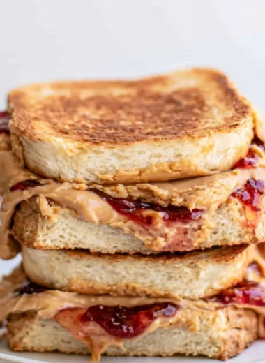 Crispy Air Fryer PB&J sandwich served on a plate with a side of berries.