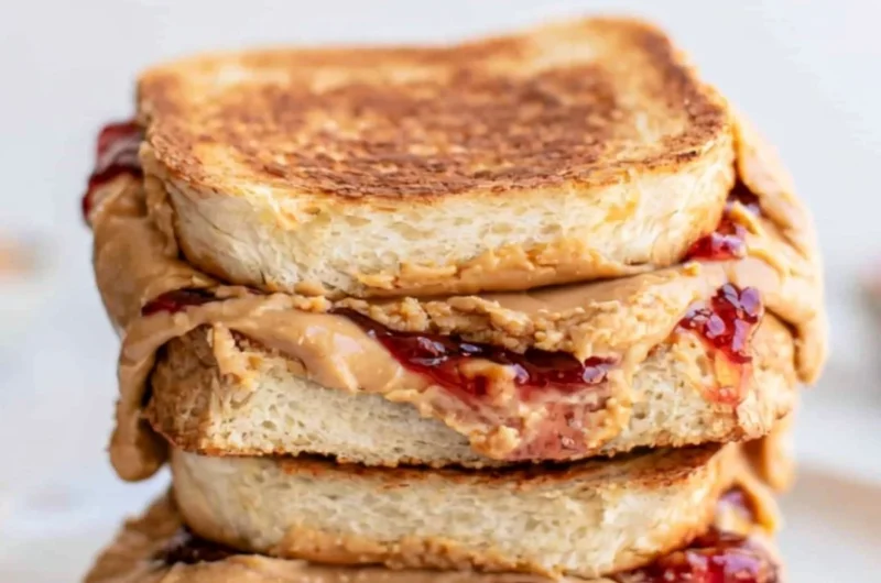 Crispy Air Fryer PB&J sandwich served on a plate with a side of berries.