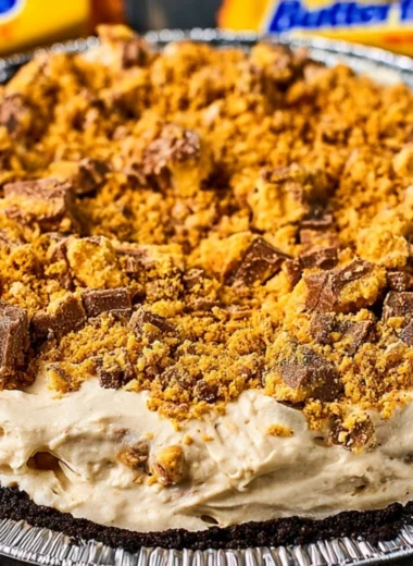 Delicious Butterfinger Pie topped with chocolate and crushed Butterfinger bars.