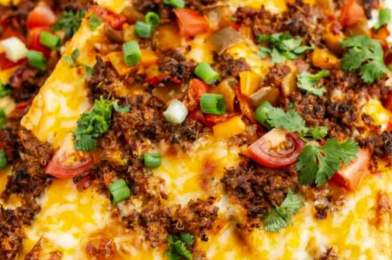 Cozy air fryer nachos topped with cheese, jalapeños, and fresh veggies.