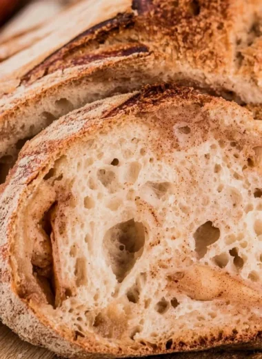 Freshly baked cozy apple cider sourdough loaf on a wooden table