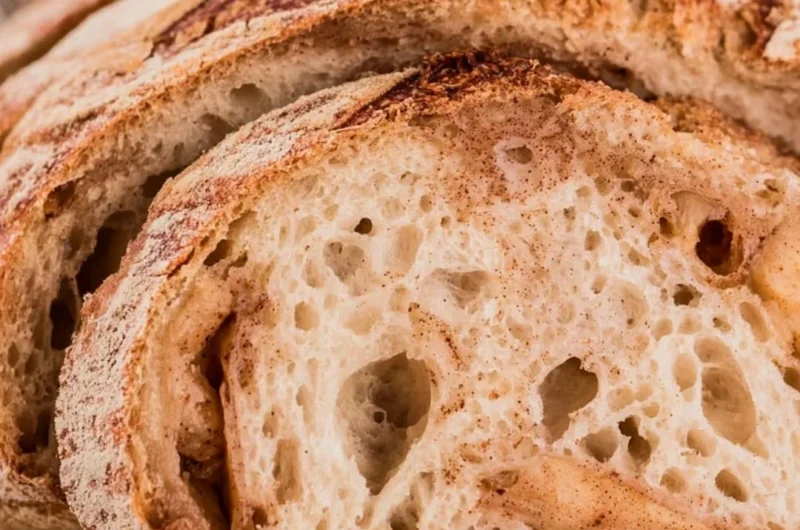 Freshly baked cozy apple cider sourdough loaf on a wooden table