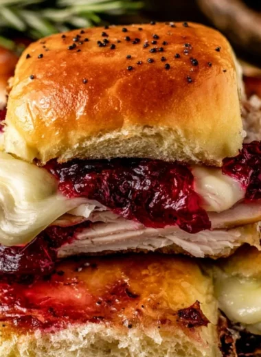 Cranberry Turkey Sliders garnished with fresh herbs on a serving platter