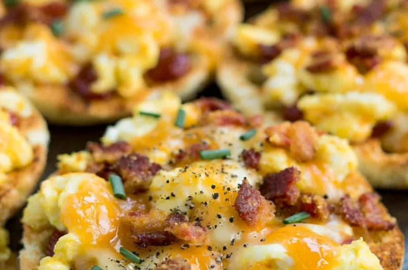 Delicious English Muffin Breakfast Pizzas topped with eggs, cheese, and veggies