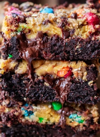 Decadent Monster Cookie Fudgy Brownies topped with chocolate chips and M&Ms