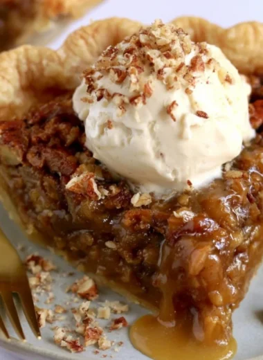 Delicious slice of homemade pecan pie with a golden crust and nuts on top