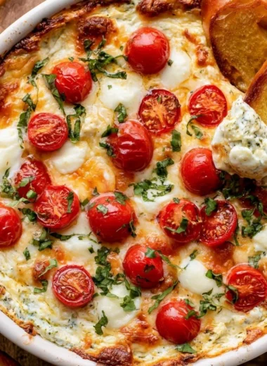 Delicious warm Caprese Dip with mozzarella, tomatoes, and basil served in a bowl