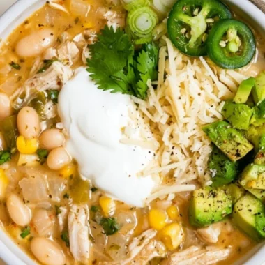 A hearty bowl of cozy white bean chili garnished with parsley and served with crusty bread.