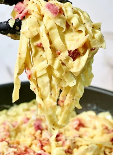 Creamy cabbage carbonara dish garnished with parsley and cheese