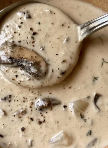 Bowl of creamy mushroom soup garnished with fresh herbs