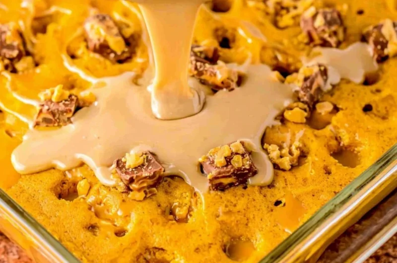 Deliciously moist Pumpkin Spice Poke Cake topped with whipped cream and spices.
