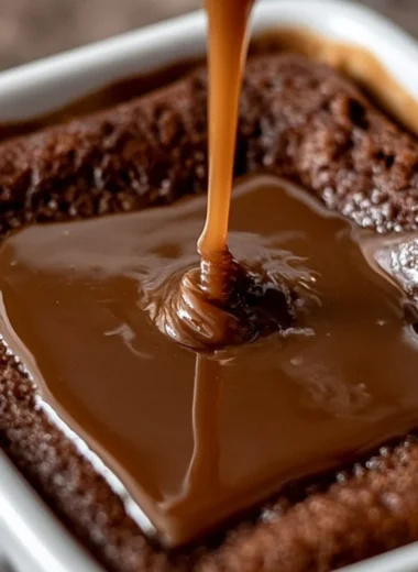 Delicious sticky toffee pudding served with creamy sauce and a sprig of mint